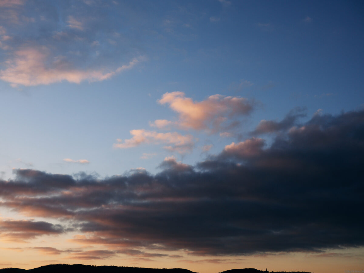 the view of the Hercules in Kassel with the Habichtswald with colorful sunset clouds