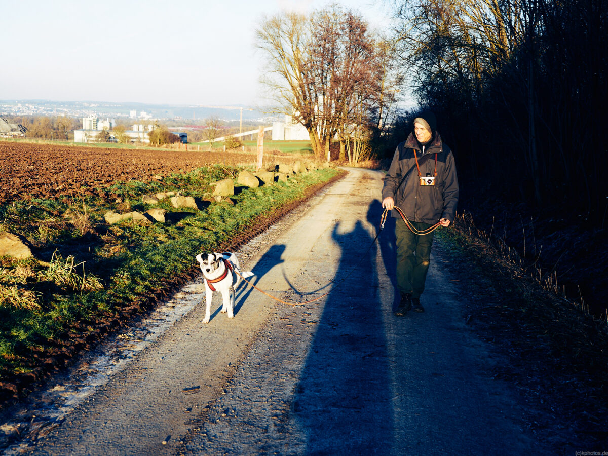 a kind of family portrait on a country lane, you can see my shadow and me waving, my husband coming towards me with our dog