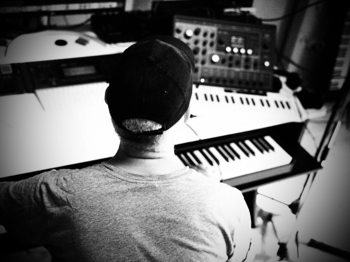 Herr K. sits in front of his keyboard with his back to the camera.