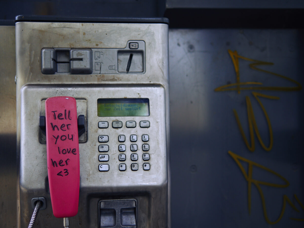 old telephone booth, with a sign on the receiver saying that you should tell her that you love her